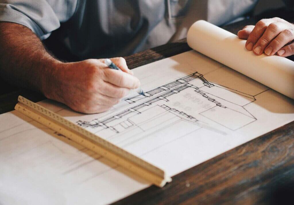 person working on blueprints at a table